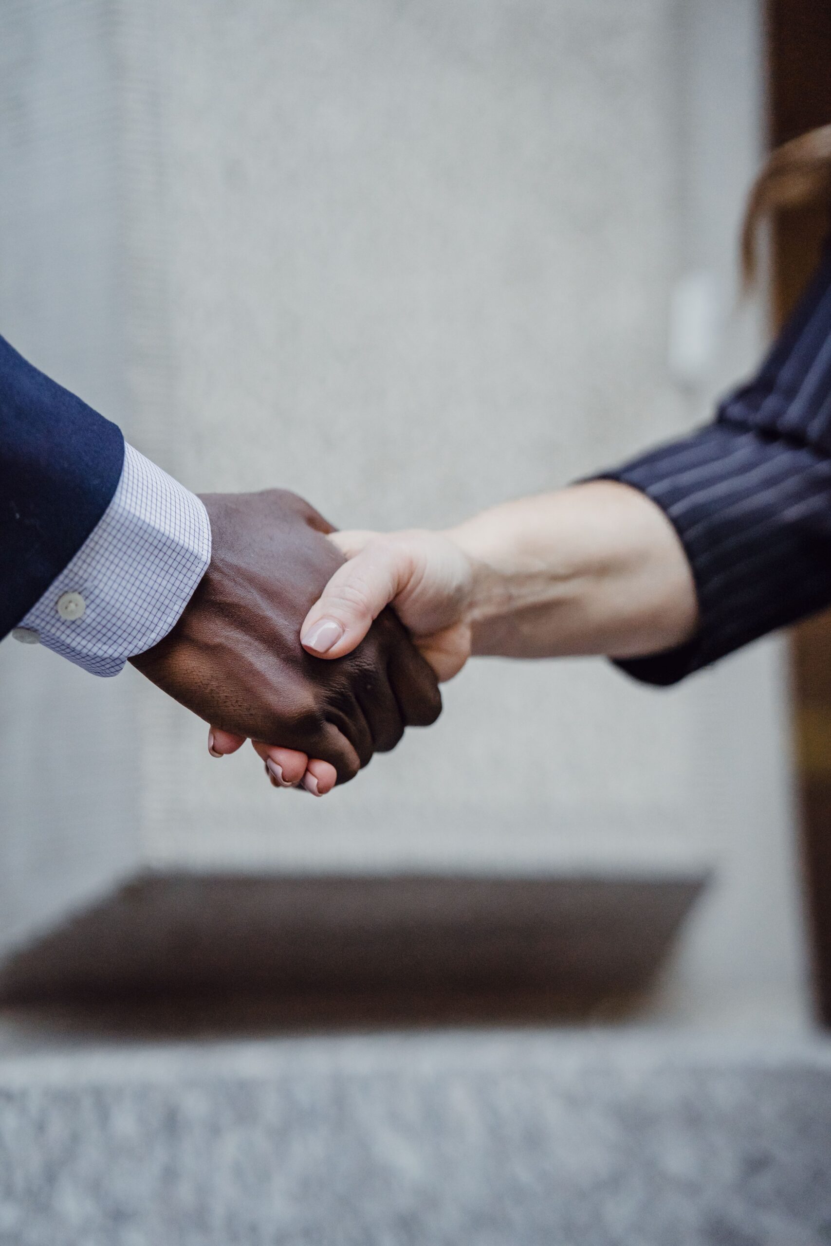 Close-up photo of diverse hands shaking, symbolizing partnership and cooperation.